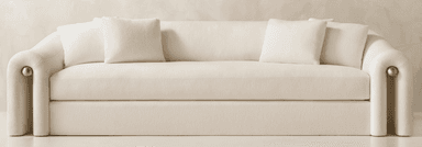 A modern three-seater sofa featuring a distinctive curved silhouette and rolled arms, upholstered in a cream-colored fabric. The arms are accented with subtle brass details at the front base. It has a single, long seat cushion and two loose back cushions. — 3D model