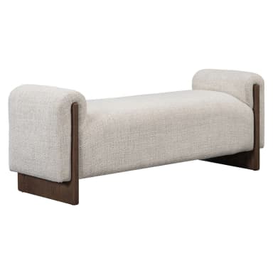 A modern upholstered bench with a textured, light-colored fabric and dark wood accents. The bench features a low profile, rounded armrests on both ends that extend slightly upwards, and a rectangular seat. The base consists of two dark wood legs, one at each end, with a unique angular design that provides support and visual interest. The overall aesthetic is minimalist and sophisticated. — 3D model