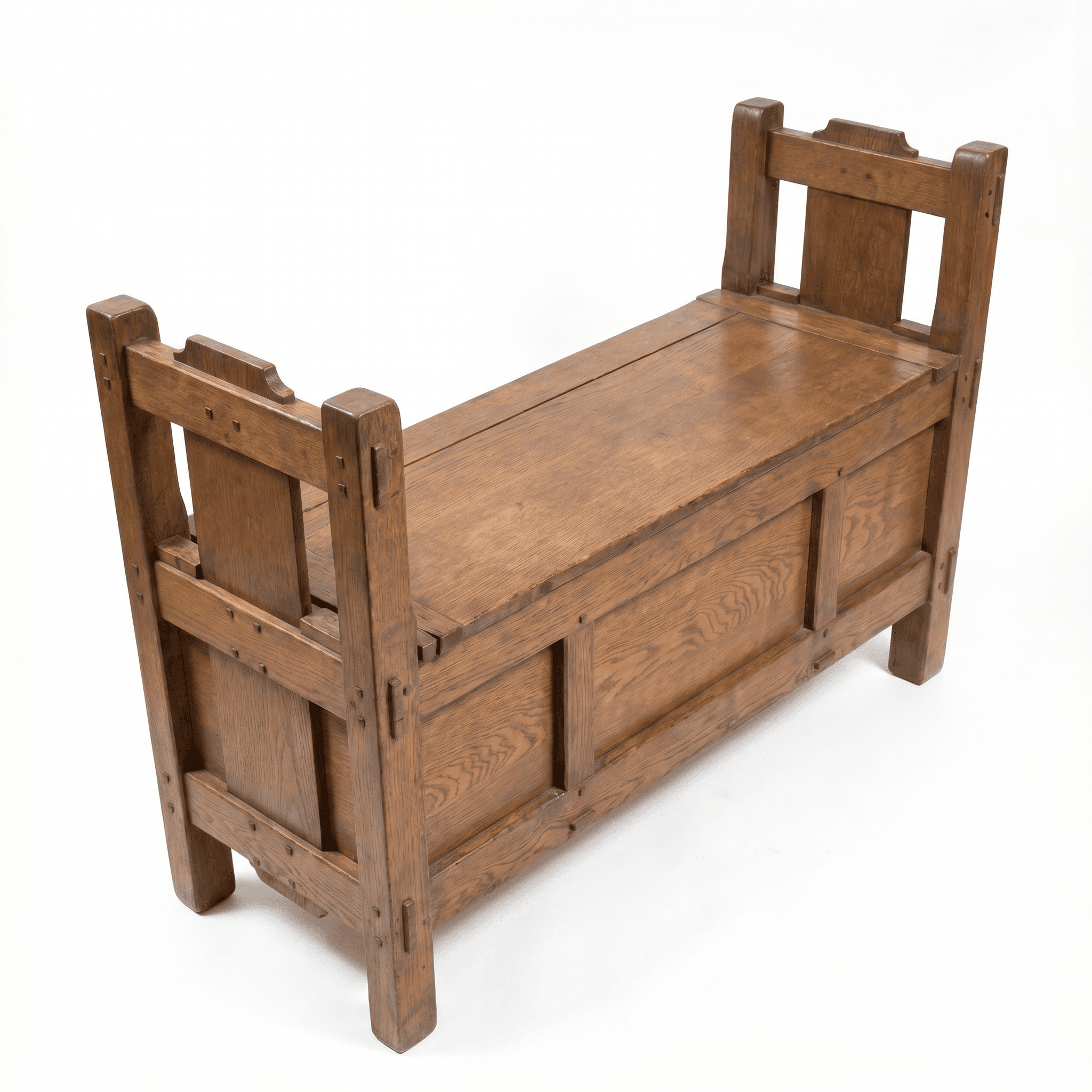 A robust, rectangular wooden bench constructed from solid oak, featuring a lift-top seat that reveals internal storage. The design exhibits classic Arts and Crafts characteristics with exposed joinery, straight lines, and a sturdy, plank-like construction. It has a high backrest and closed armrests with a slight overhang, adding to its architectural presence. The wood displays a warm, medium brown finish with a visible grain. — 3D model