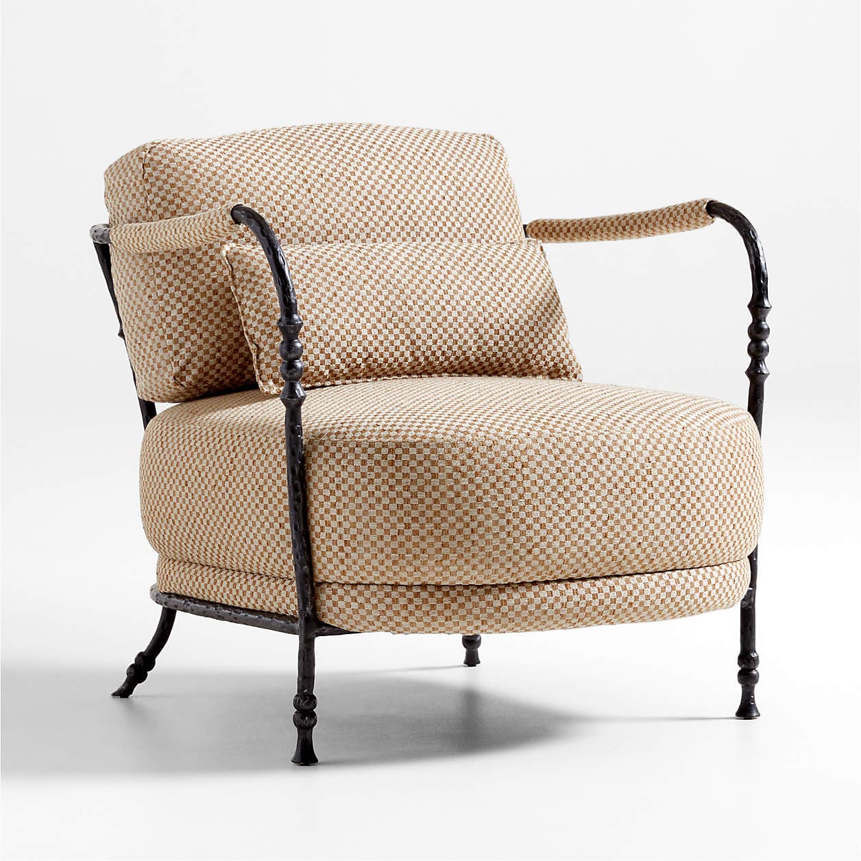 A single armchair with a rounded back and seat, featuring dark, ornate metal legs and armrests. The upholstery is a textured fabric with a small checkered pattern in beige and white. A lumbar pillow with matching upholstery is placed on the seat. — 3D model