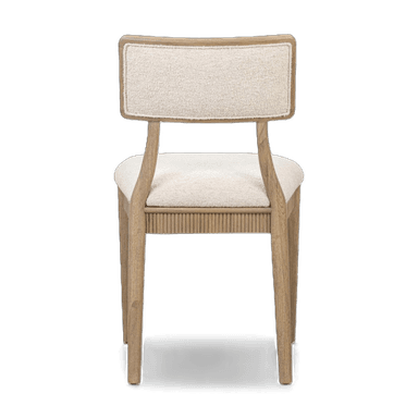 A dining chair with a wooden frame and upholstered seat and backrest. The seat and backrest are covered in a textured, light-colored fabric. The wooden frame has a light, natural finish and features a fluted design along the apron below the seat. The backrest is rectangular with gently rounded corners and is supported by two curved wooden uprights. — 3D model