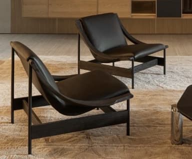 A modern lounge chair featuring a dark stained wooden frame with gracefully curved armrests and black upholstered seat and back cushions, designed for comfortable relaxation. — 3D model