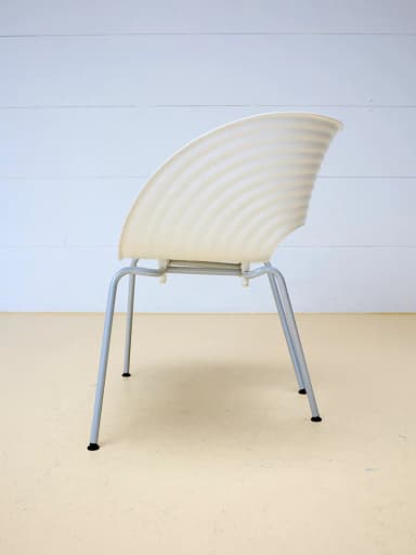 A modern white molded chair featuring a distinct wavy, ridged surface texture and a unique cutout in the seat. It is supported by slender metal legs. — 3D model