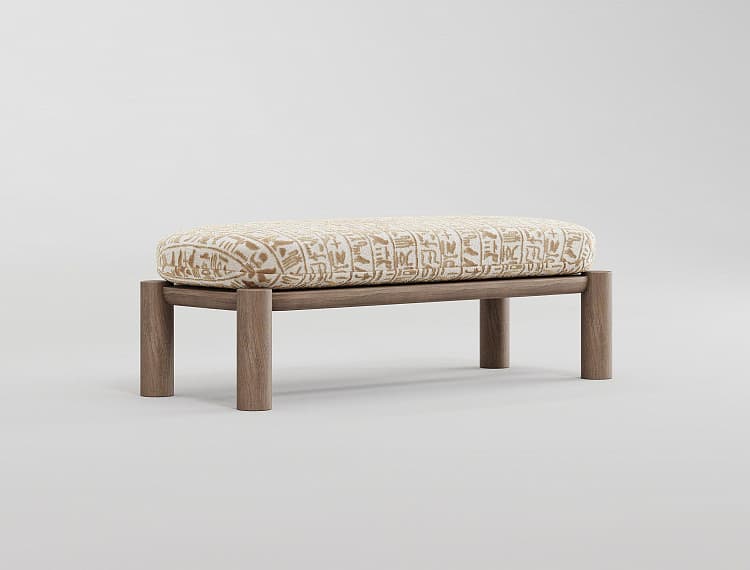 A rectangular bench with a wooden frame and a cushioned top. The wooden frame consists of four cylindrical legs supporting a flat, rectangular wooden base. The cushioned top is upholstered with fabric featuring a pattern resembling hieroglyphs or ancient script in a beige and brown color scheme. — 3D model