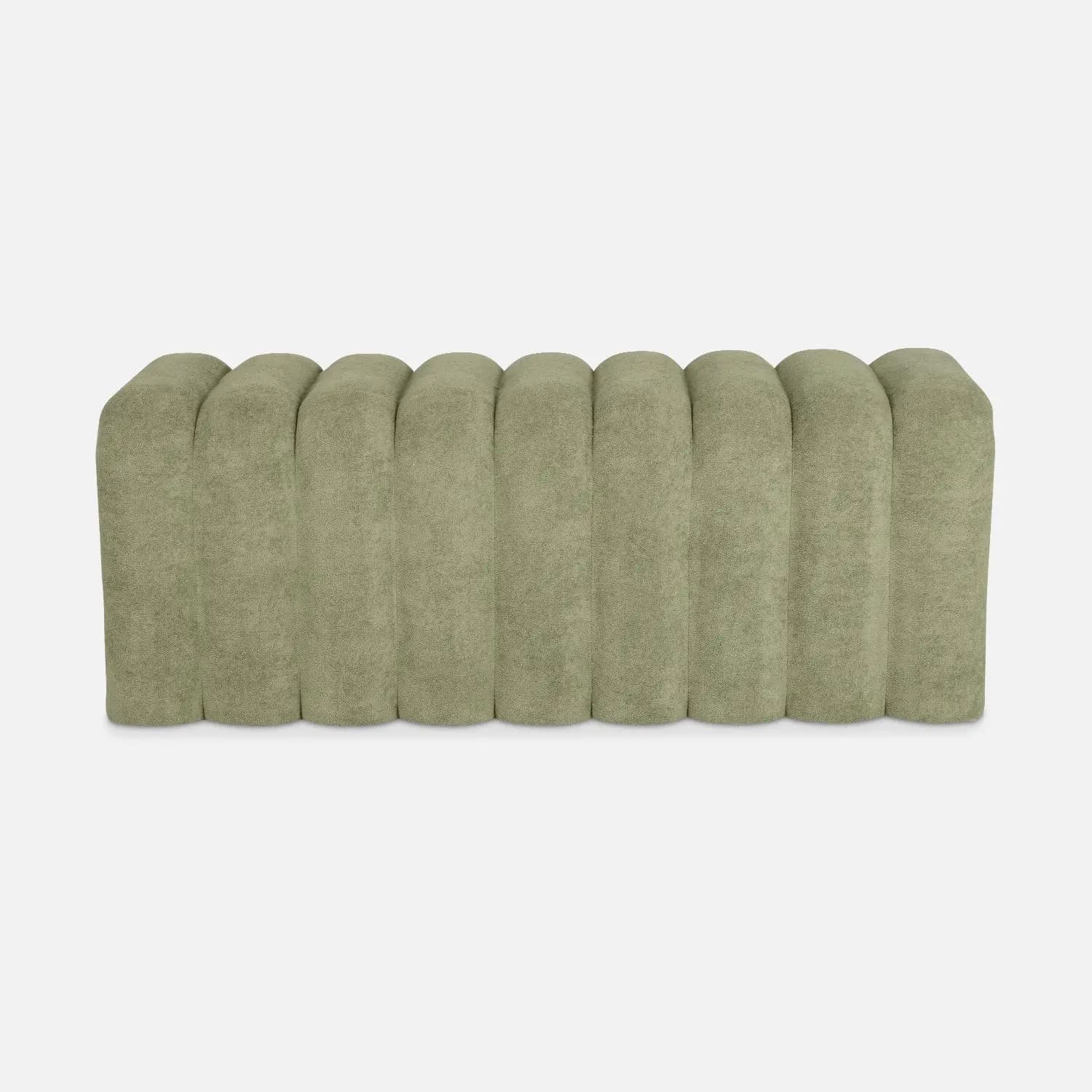 A plush bench with a channeled or fluted design. The piece features vertical, rounded channels across its surface, creating a consistent, textured aesthetic. It appears to be upholstered and has a low profile, suggesting it could be used for seating or as an ottoman. — 3D model