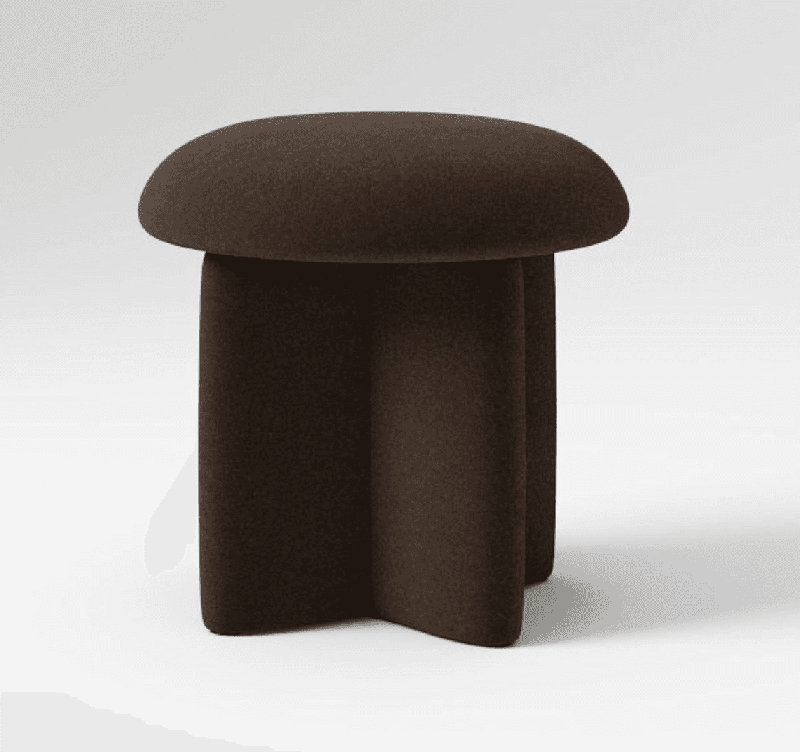 A dark brown stool with a rounded, slightly convex top and a base composed of three rounded, columnar legs that splay outwards at the bottom, forming a unique star-like footprint. The stool appears to be upholstered in a textured fabric. — 3D model