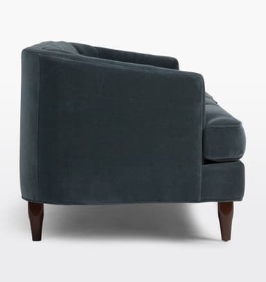A three-seater sofa with a tufted back and seat cushions. The sofa features a rounded armrest profile and is supported by tapered wooden legs. The upholstery appears to be a dark teal or navy blue velvet fabric. — 3D model
