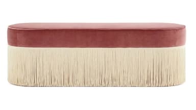 An oval-shaped bench upholstered in pink velvet, featuring a long, cream-colored fringe around its entire base. — 3D model
