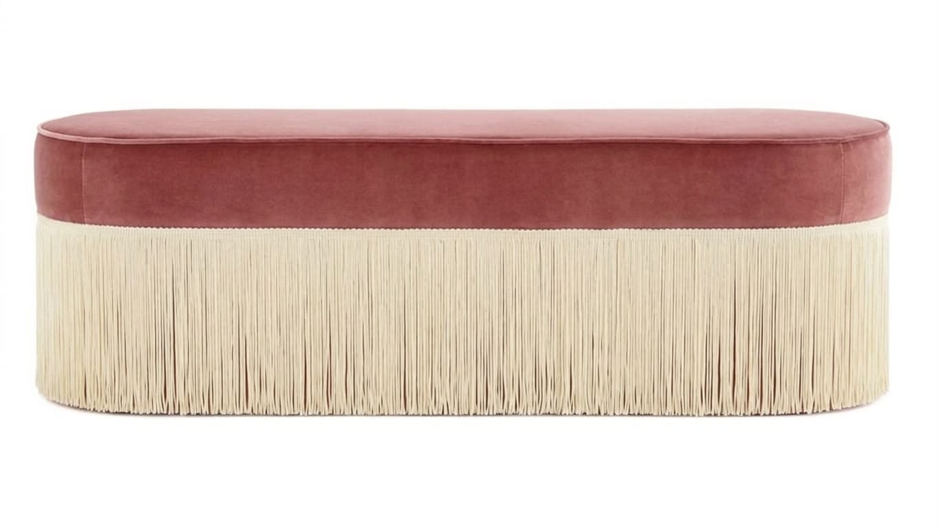 An oval-shaped bench upholstered in pink velvet, featuring a long, cream-colored fringe around its entire base. — 3D model