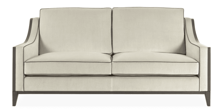 A contemporary two-seater loveseat featuring a prominent exposed dark wood frame and light-colored fabric upholstery. The sofa has a 'two-over-two' cushion configuration, meaning two seat cushions and two back cushions, all tailored with visible contrast piping. The arms are formed by the exposed wood frame, which extends around the back and down to form tapered block legs. — 3D model