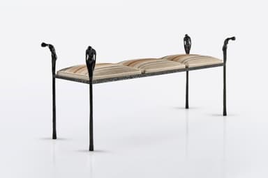 A distinctive figural wrought iron bench featuring a dark, textured metal frame with decorative uprights sculpted as human figures, supporting segmented upholstered cushions with a striped pattern. The bench has four slender legs and decorative arm-like elements at each end, also featuring figural motifs. — 3D model
