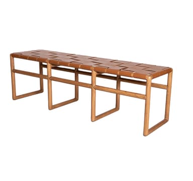 A long, rectangular bench featuring a light-toned wooden frame and a tan woven leather seat. The frame consists of three inverted U-shaped sections, connected by horizontal stretchers, providing a sturdy and minimalist base. The seat is formed by wide strips of leather interlaced in a basket-weave pattern. — 3D model