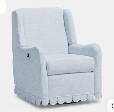 A light blue upholstered recliner featuring a distinctive scalloped skirt around its base and integrated armrests. A control button for recline is visible on the side. — 3D model