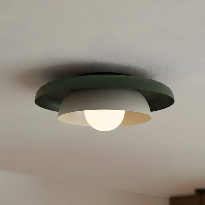 A modern ceiling light fixture featuring a layered design. The outermost shade is a wide, shallow dark green metal disc, while an inner, smaller, light grey or beige dome-shaped shade is positioned beneath it. A spherical white diffuser protrudes from the center of the inner dome, emitting a soft, diffused light. The fixture appears to be designed for flush or semi-flush mounting to a ceiling. — 3D model