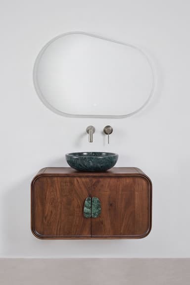 A contemporary wall-mounted bathroom vanity cabinet crafted from dark-stained walnut wood, featuring gracefully rounded edges. It is topped with a distinct dark green marble vessel sink and includes matching, organically shaped marble door pulls. A wall-mounted brushed metal faucet set completes the unit. — 3D model