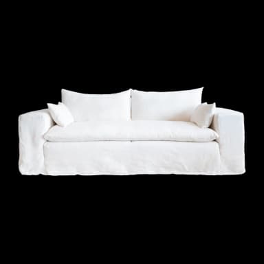 A white slipcovered sofa with two seat cushions and two back cushions. Two small accent pillows are placed on either end of the sofa. The sofa has a relaxed, casual style with a skirted base. — 3D model