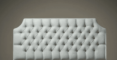 A light blue upholstered headboard with a tufted design. The tufting creates a diamond pattern with buttons at each intersection. The headboard has a slightly arched top and is mounted on a base that is not fully visible. — 3D model