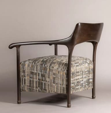 A modern armchair featuring a dark, sculptural wooden frame that forms the armrests, backrest, and legs. The armrests curve gracefully, extending from the backrest and supported by a leg structure. The seat is upholstered in a textured fabric with a multi-tonal geometric pattern in shades of beige, grey, and subtle orange. The chair presents a contemporary aesthetic with clean lines and organic shapes. — 3D model