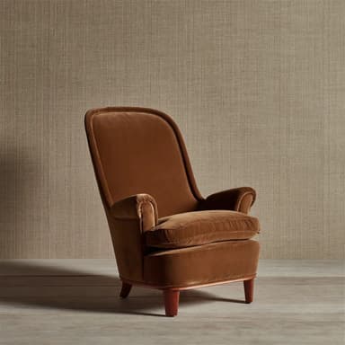 A plush, brown velvet upholstered lounge armchair featuring a high, gently curved backrest, rolled arms, and a deep, removable seat cushion. The chair sits on four short, tapered wooden legs. — 3D model