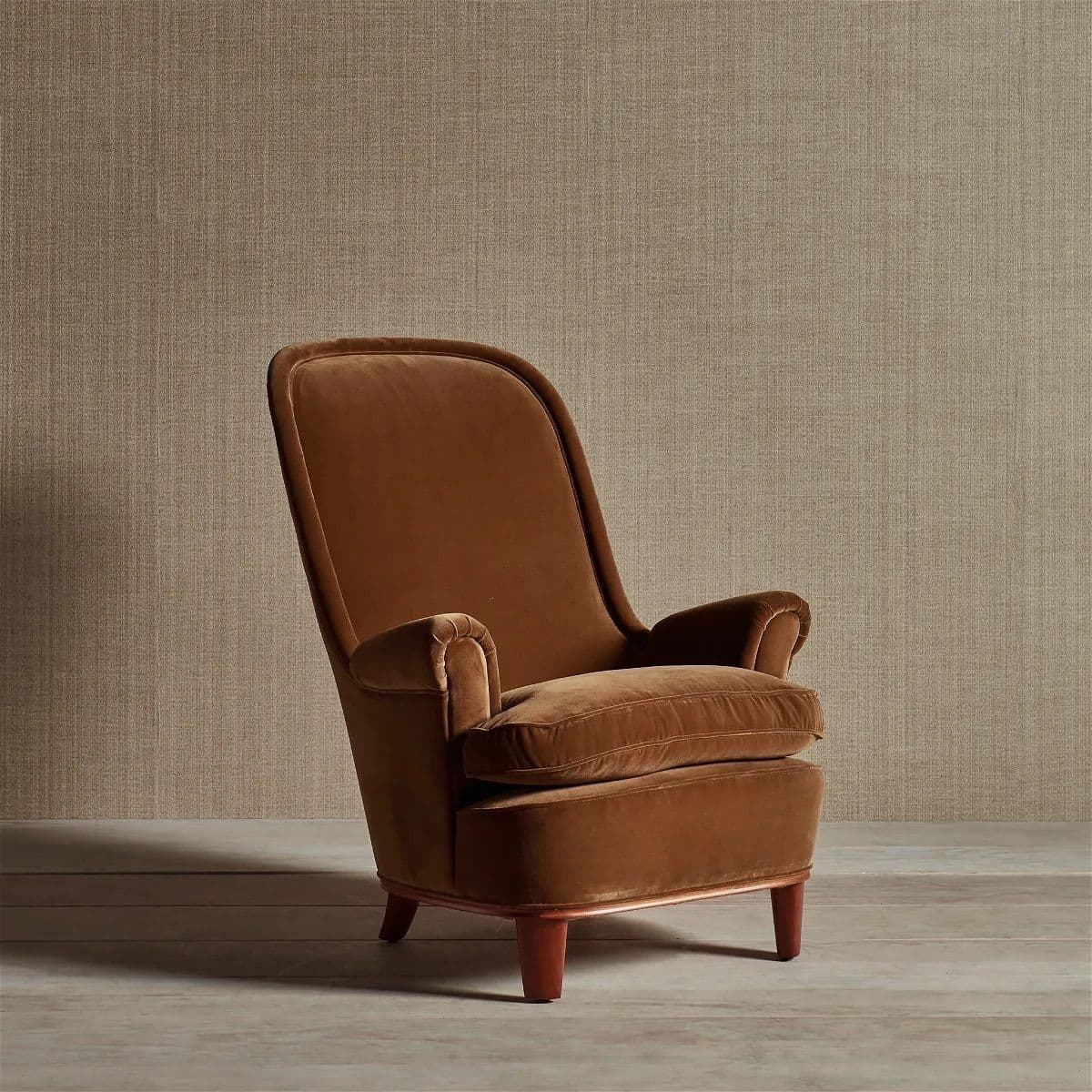 A plush, brown velvet upholstered lounge armchair featuring a high, gently curved backrest, rolled arms, and a deep, removable seat cushion. The chair sits on four short, tapered wooden legs. — 3D model
