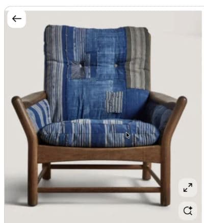 A lounge chair featuring a sturdy wooden frame with rounded armrests and plush, button-tufted cushions upholstered in a distinctive blue patchwork textile. — 3D model