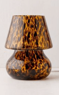 A small table lamp featuring a distinctive tortoiseshell pattern across both its rounded base and conical shade. The lamp appears to be made of glass or acrylic, presenting warm brown and amber hues with darker speckled markings. — 3D model