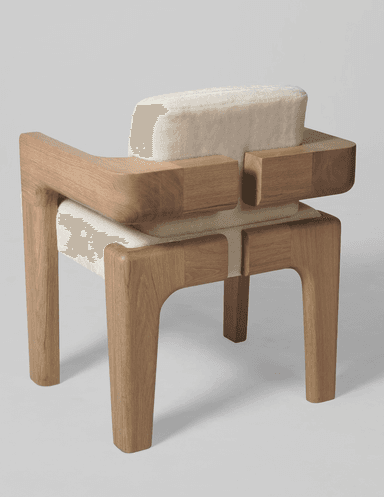 An armchair with a distinct contemporary design. The frame is constructed from light-colored wood with a visible grain, featuring robust legs and armrests. The seat and backrest are upholstered in a textured, off-white fabric that appears soft and plush. The design incorporates geometric shapes, with the wooden elements forming block-like structures that cradle the upholstered cushions. — 3D model
