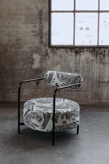 A contemporary round accent chair featuring a black tubular metal frame and black and white graphic patterned upholstery. — 3D model