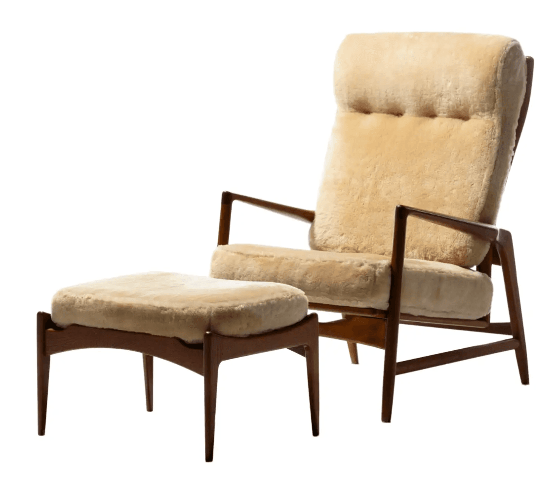 A mid-century modern armchair with a matching ottoman. The armchair features a high back and armrests supported by a dark wood frame. Both the seat and back cushions, as well as the ottoman's top surface, are upholstered in a textured, light beige sheepskin or similar furry material. The ottoman has a low profile with four tapered legs. — 3D model