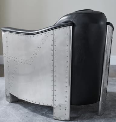 A black leather armchair with a diamond-stitched pattern on the seat and back. The armchair features polished aluminum or metal accents on the arms and base, with visible rivets along the edges of the metalwork. The design evokes an aviator or industrial aesthetic. — 3D model