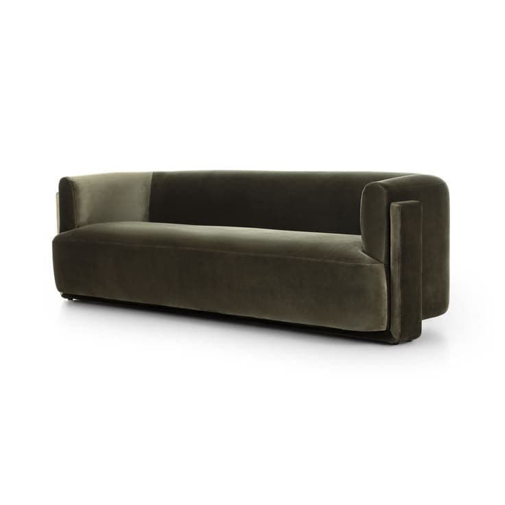 A contemporary sofa with a low profile and clean lines. The upholstery appears to be a soft velvet fabric. It features a slightly curved back and distinctive armrests with a stepped design. The color transitions subtly along the backrest, suggesting either a color gradient in the fabric or a difference in lighting. — 3D model