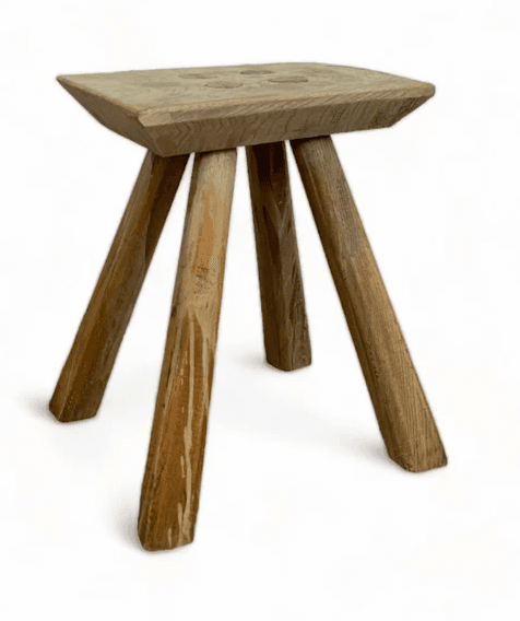 A rustic, three-legged stool with a flat, rectangular top and three roughly shaped legs. The wood appears to be aged and unfinished. — 3D model