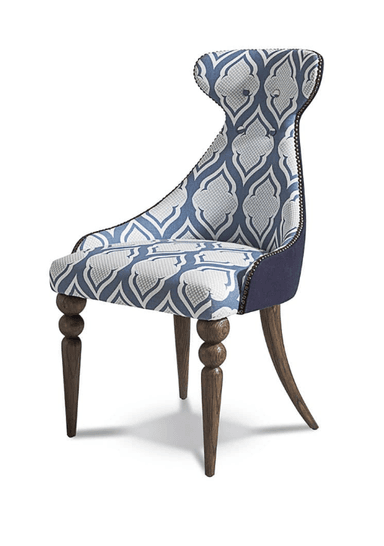 A high-backed armchair with a distinctive silhouette, featuring upholstery with a blue and white geometric pattern. The chair has four legs, with the front legs exhibiting a turned design with spherical elements, and the back legs are more slender and curved. Decorative nailhead trim lines the edges of the upholstery. — 3D model