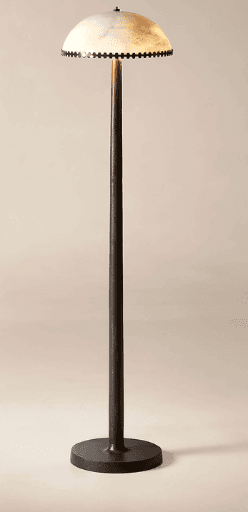 A standing lamp with a dark, slender pole and a domed, translucent lampshade. The lampshade features a decorative border along its lower edge, composed of what appear to be small, dark beads or studs. The base is circular and wide, providing stability. — 3D model