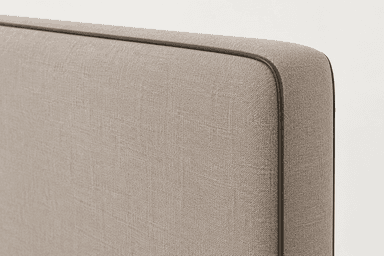 A rectangular upholstered headboard in a light beige fabric with subtle dark piping along its rounded edges and small integrated feet. — 3D model