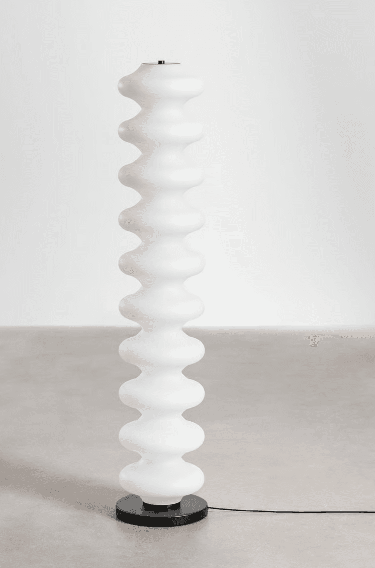 A tall, slender contemporary floor lamp featuring a column of stacked, frosted ovoid segments. The segments diffuse light evenly, creating a soft ambient glow. The lamp is supported by a flat, circular black base, and topped with a small, flat black cap, maintaining a minimalist aesthetic. — 3D model