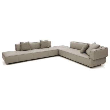 A contemporary sectional sofa with a chaise lounge. The sofa features a light beige or cream-colored upholstery with subtle stitching details creating a segmented appearance on the seating and back cushions. It includes two accent throw pillows in a similar neutral tone. A section of the sofa incorporates a light-colored, possibly marble or stone, tabletop integrated into its structure. The sofa is presented on a black background. — 3D model