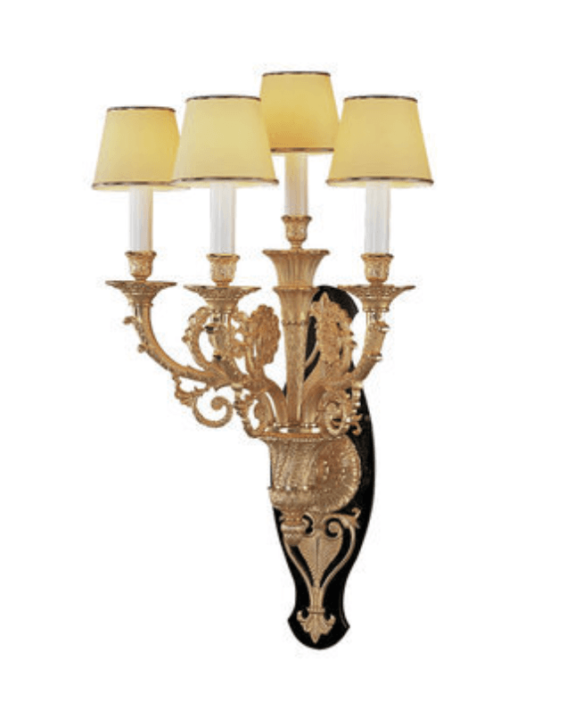 A decorative wall sconce featuring an ornate gilded metal structure with five candle-style lights. The sconce has a black backing plate with intricate gold detailing. Each light is topped with a pale yellow fabric shade with a dark trim. — 3D model