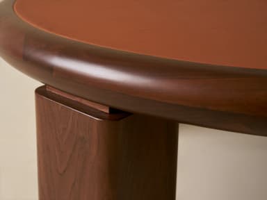 A low, round coffee table featuring a light-colored natural stone top, likely travertine, set within a thick, rounded frame of dark wood. The table is supported by four robust, chunky cylindrical wooden legs. — 3D model