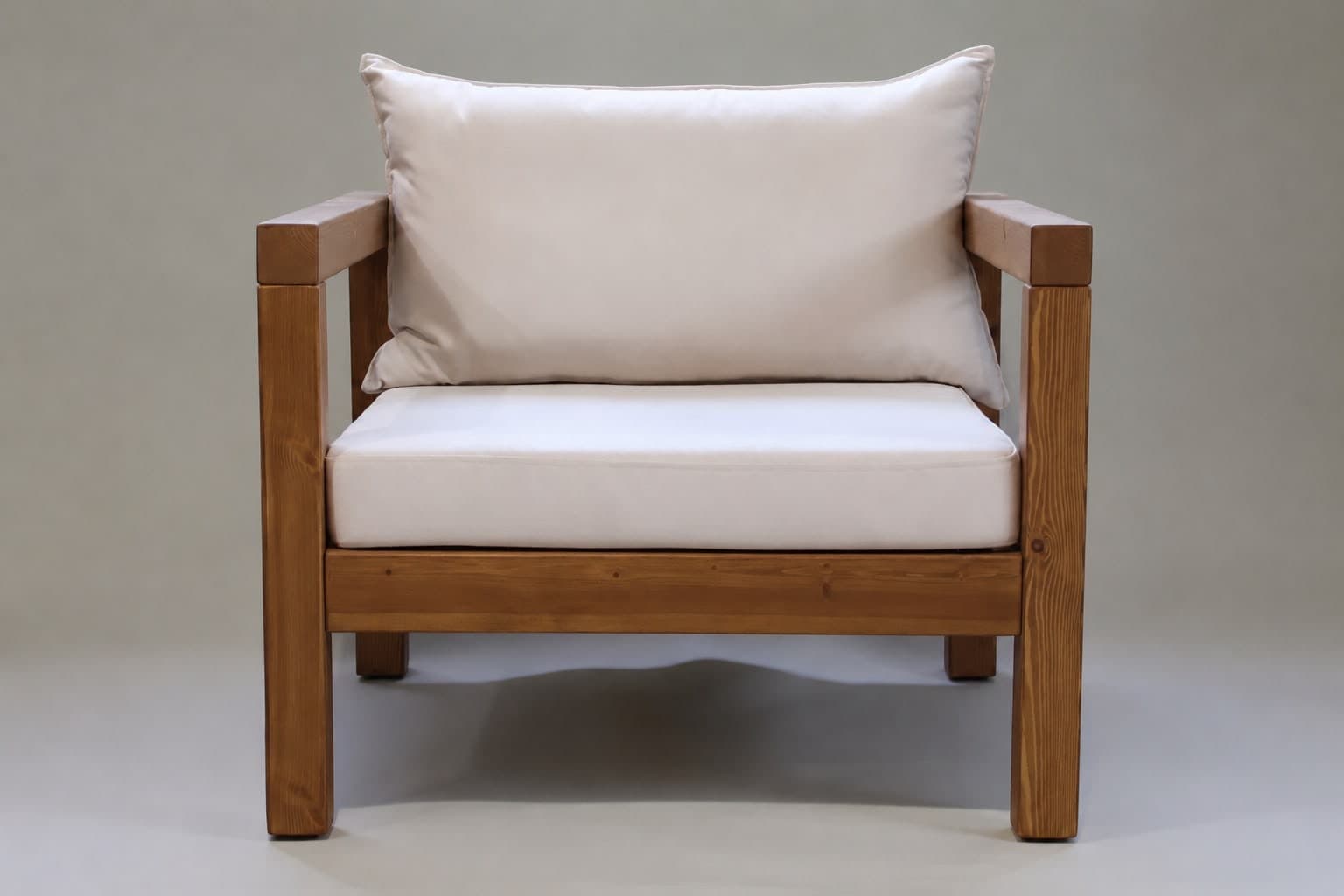 A sturdy armchair featuring a robust wooden frame and plush, light-colored cushions for seating and back support. The design is rectilinear and minimalist. — 3D model