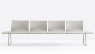 A long, grey, multi-seat bench designed for public waiting areas, featuring four individual seating units with slightly curved backrests and flat seats, flanked by integrated flat side tables. The entire structure is supported by minimalist U-shaped metal legs. — 3D model