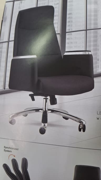 A high-back executive office chair upholstered in black synthetic leather, featuring padded armrests with chrome accents. It has a polished chrome five-star swivel base equipped with five black casters for mobility. The chair includes visible levers for height adjustment and recline control, typical of an office task chair. — 3D model