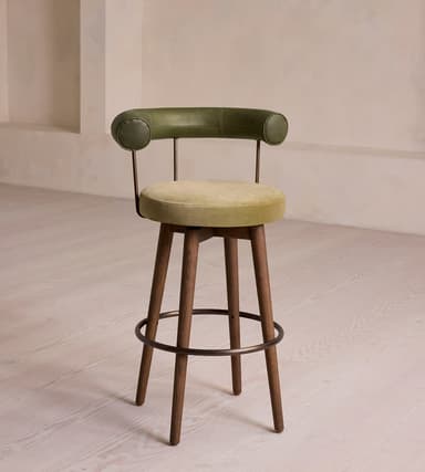 A modern bar stool featuring a rounded upholstered seat and a distinctive curved, padded backrest, supported by four tapered wooden legs connected by a circular metal footrest. — 3D model