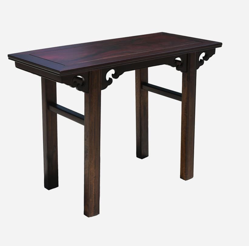 A rectangular, dark-stained wooden console table with a slightly raised edge on its top surface. The table features four straight legs and a lower stretcher connecting the legs for stability. Decorative carved elements with scroll motifs are present beneath the tabletop, between the legs and the tabletop. — 3D model