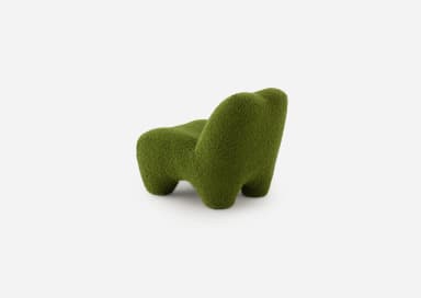 A low-slung, green, organic shaped lounge chair, entirely upholstered in a textured boucle fabric with a sculptural form, devoid of visible legs or distinct base. — 3D model