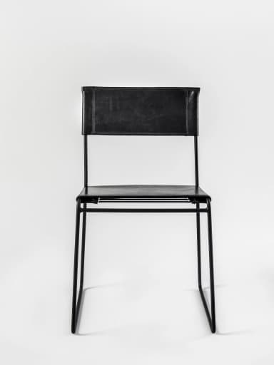 A contemporary armless chair featuring a minimalist design with a black metal sled frame and black leather upholstery for the seat and back. — 3D model