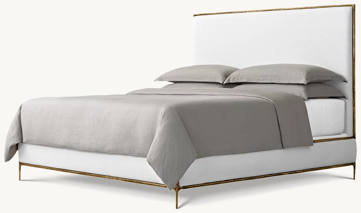 A contemporary bed featuring a tall, rectangular upholstered headboard and an exposed, hammered gold-finished metal frame that outlines the headboard and forms the base and slender legs. — 3D model