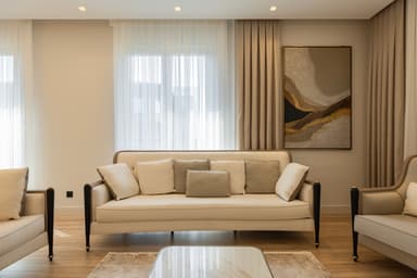 A refined three-seater sofa featuring a high, gently curved backrest and flat, dark-stained wooden armrests. The sofa is upholstered in a light beige or cream fabric, complemented by a selection of coordinating throw pillows in similar and slightly darker beige tones. It stands on short, tapered dark wooden legs finished with metallic gold or brass ferrules. — 3D model