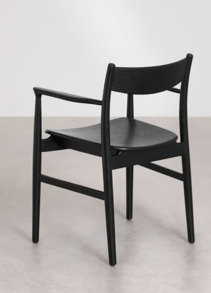 A modern black-stained wooden armchair with a minimalist design, featuring a gently curved backrest, integrated armrests, and a solid wood seat. The chair's legs are slightly tapered, contributing to its sleek aesthetic. — 3D model