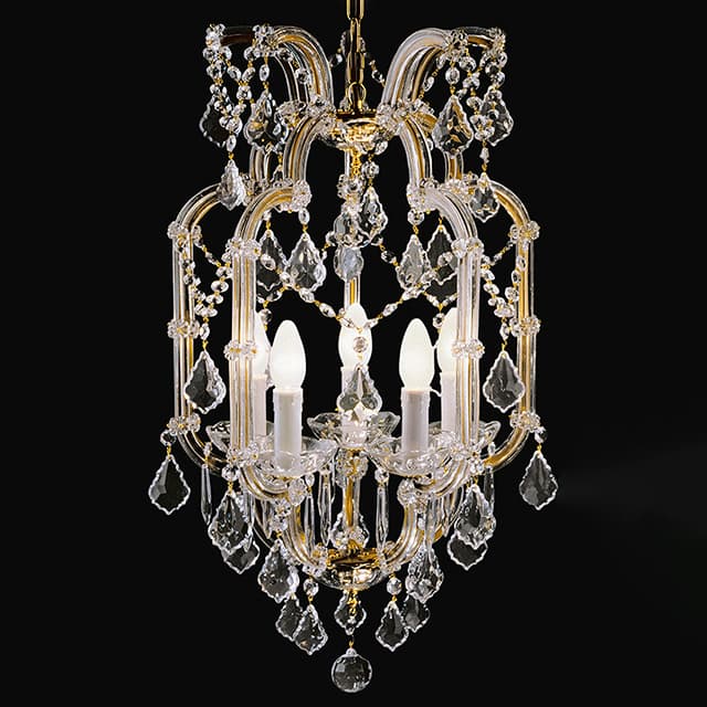 A multi-tiered chandelier constructed with a gold-toned metal frame. The frame features curved elements and is adorned with numerous clear, faceted crystal pendants and beads, creating a sparkling effect. It has multiple candle-shaped light bulbs with white covers, emitting a warm light. The overall design suggests a classical or baroque influence. — 3D model
